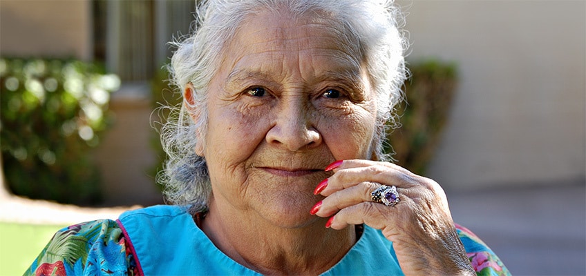 An older woman outside smiling.