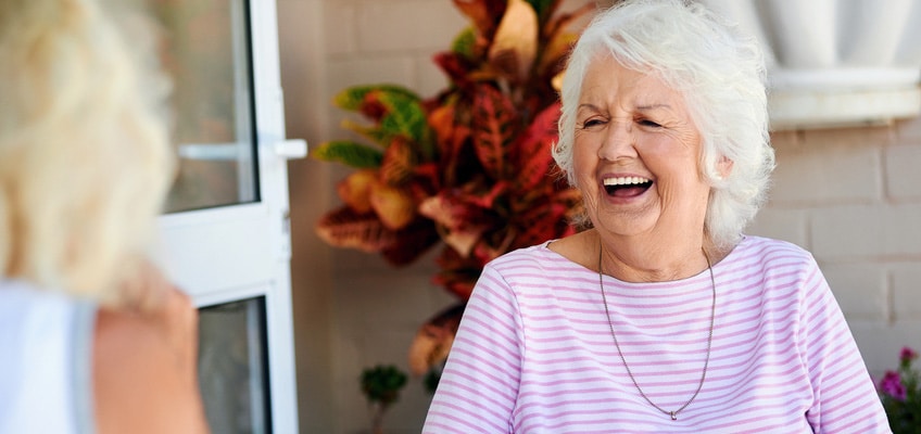 A woman outside laughing.