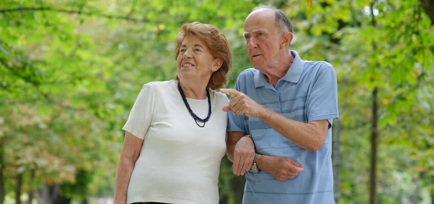Two people walking through a park together.